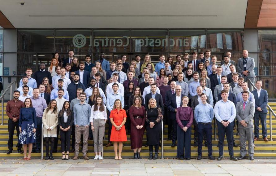 Group of our apprentices and graduates on steps in Manchester city center.